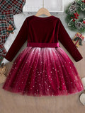 Red velvet dress with a tulle skirt on a hanger against a festive background.