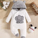 White baby onesie with gray elephant design and hood on a textured surface.