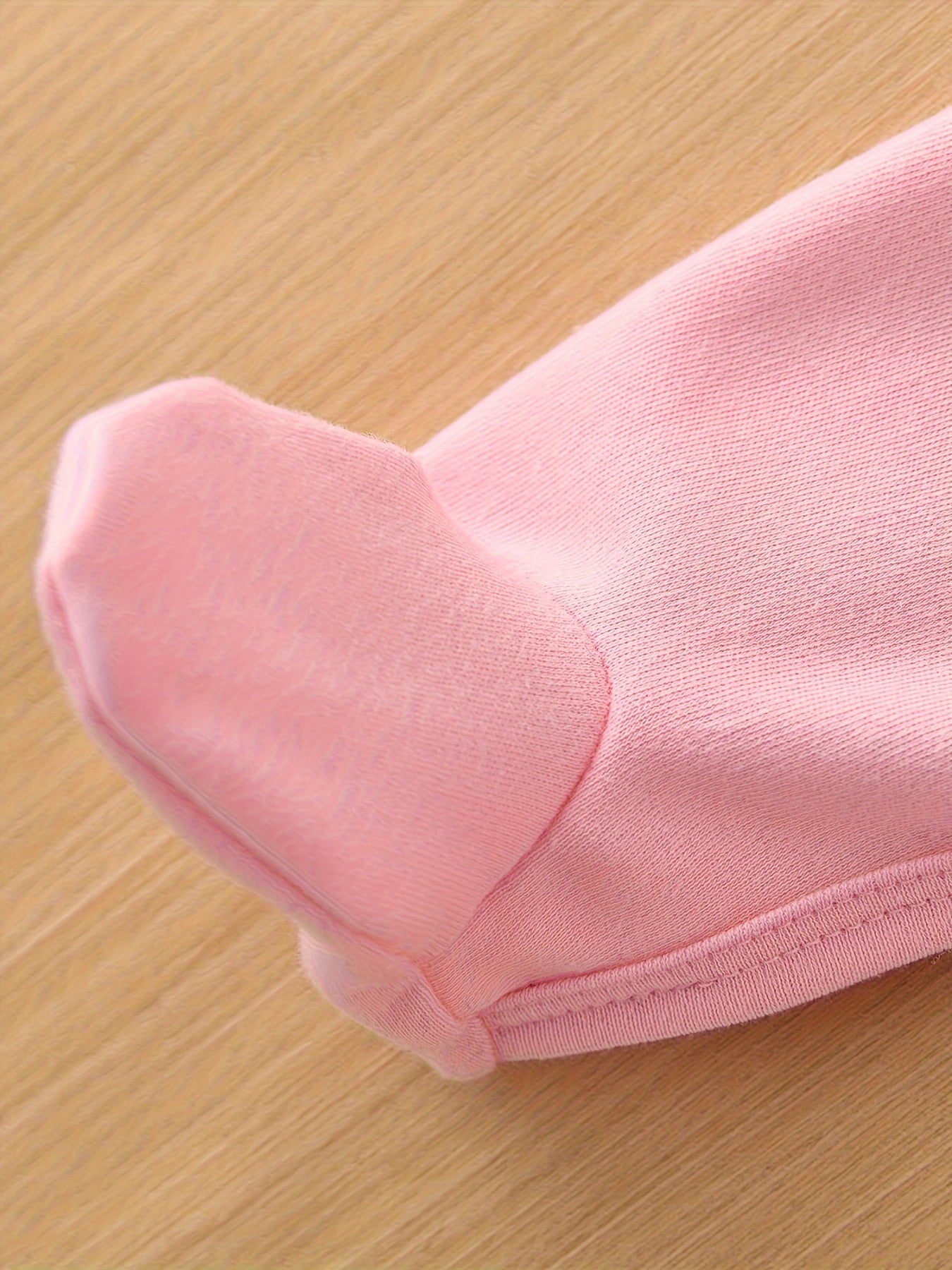 Close-up of a pink fabric item on a wooden surface