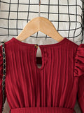 Red dress on a hanger against a grid-patterned background