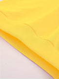 Close-up of yellow fabric with a textured pattern on a light pink background