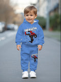 Child wearing a blue hoodie and pants set with Spider-Man design on a street.