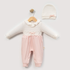 A baby girl's two-piece outfit set consisting of a long-sleeve jumpsuit and a matching knit bonnet. The jumpsuit features a textured cream-white top with a ruffled collar and lace trim, paired with soft pink pants.