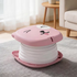 Pink and white stool with cartoon face design on a carpeted floor.