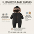 A baby winter onesie in black quilted fleece with a brown faux-fur trimmed hood and bear ears, shown on a light beige background with feature callouts and text about soft fleece fabric, quilted insulation, stylish hooded design, and size range.