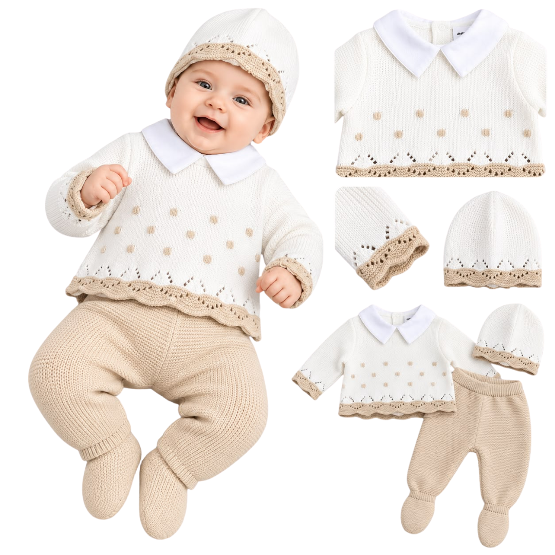 A smiling baby wearing a white and beige knit collared sweater set with matching footed leggings and a beanie.