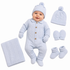 A baby wearing a light blue cable-knit one-piece outfit with a matching pom-pom beanie, laid out on a white background with matching accessories: a folded blanket, hat, mittens, and booties.