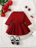 Red dress with white fur trim on a textured surface with decorative items.