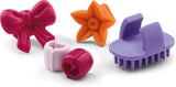 Set of colorful hair clips including a bow, flower, and textured clip on a white background