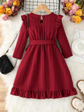 Red dress with ruffled details on a hanger against a soft white background