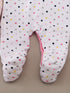 Baby onesie with polka dot pattern on a beige background