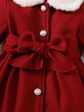 Red coat with a large bow and pearl buttons on a neutral background