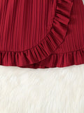 Close-up of a red pleated fabric with ruffled edge on a white background