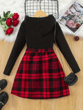 Black hoodie with red plaid skirt on a wooden surface with decorative items.