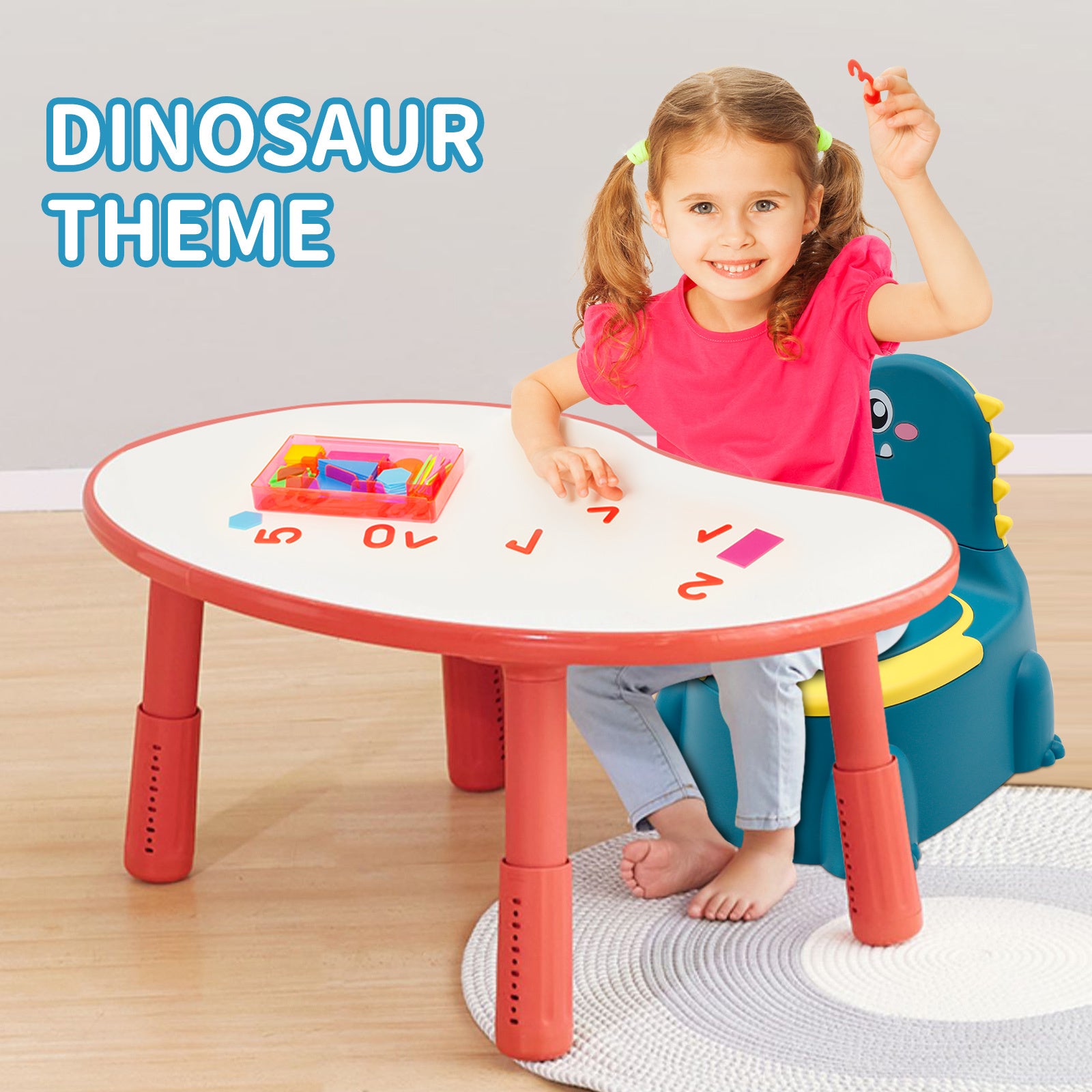 Child sitting at a red dinosaur-themed table with colorful letters, wearing a pink shirt and blue jeans.