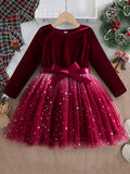 Red velvet dress with a bow on a hanger against a festive background