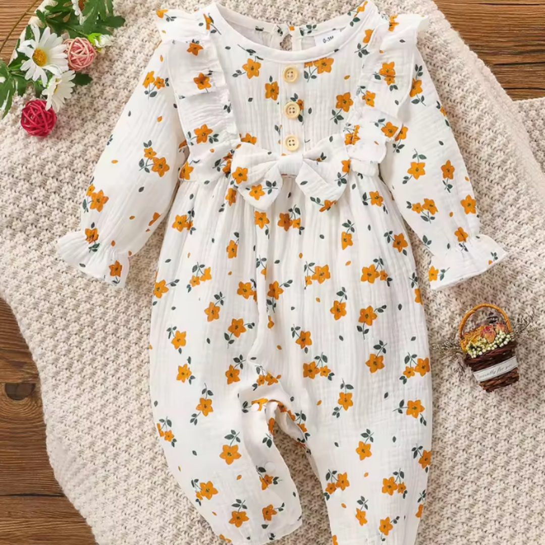 Baby romper with floral pattern on a textured surface