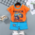 Children's outfit with orange shirt and blue shorts featuring a truck design on a gray background.