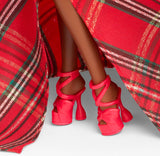 Red high-heeled shoes with a plaid fabric background