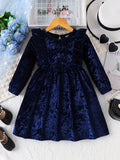 Blue velvet dress on a hanger with accessories on a textured surface