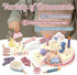 Wooden toy cake set with various accessories including numbers, candles, and snacks on a white surface.
