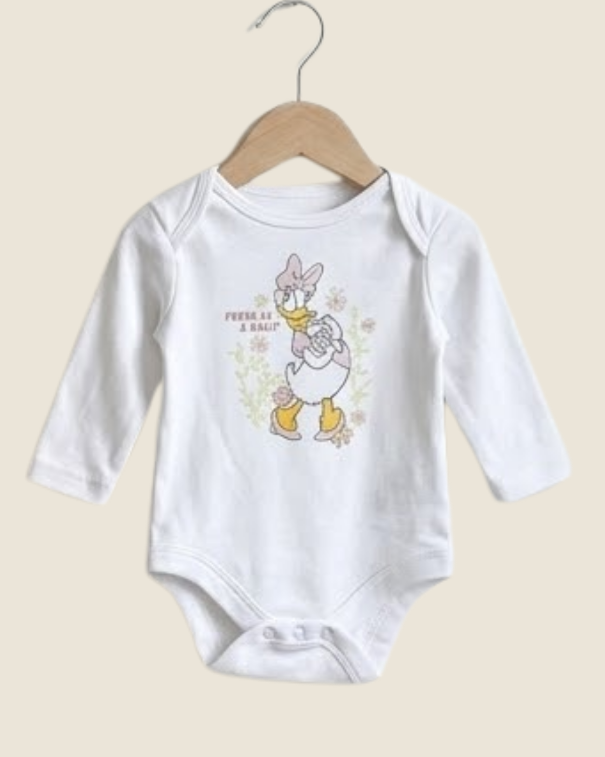 White baby onesie with cartoon character on a beige background