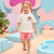 Child wearing a Minnie Mouse t-shirt and shorts in a colorful, playful setting