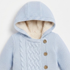 A light blue knit hooded cardigan with a cream sherpa lining and three wooden buttons, shown on a plain white background.