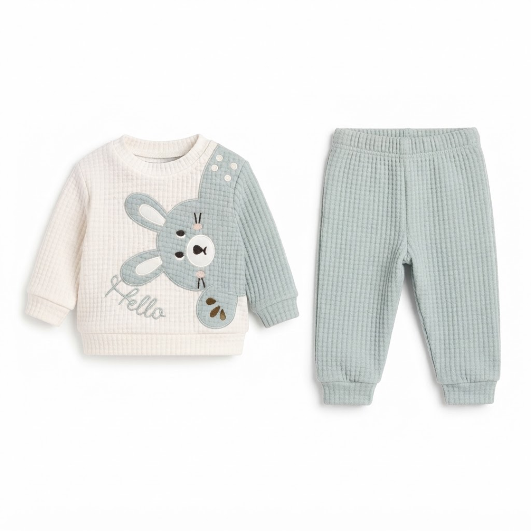 Baby two-piece waffle knit outfit set featuring a cream and sage green long-sleeve top with a cartoon bunny graphic and the word 'Hello', paired with matching sage green waffle knit pants.