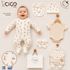 A baby outfit set displayed on a light beige background with a smiling baby lying on top. The set includes a cream-colored footless one-piece with a small orange animal print, a matching bib, a beanie, a short-sleeve bodysuit, and booties.
