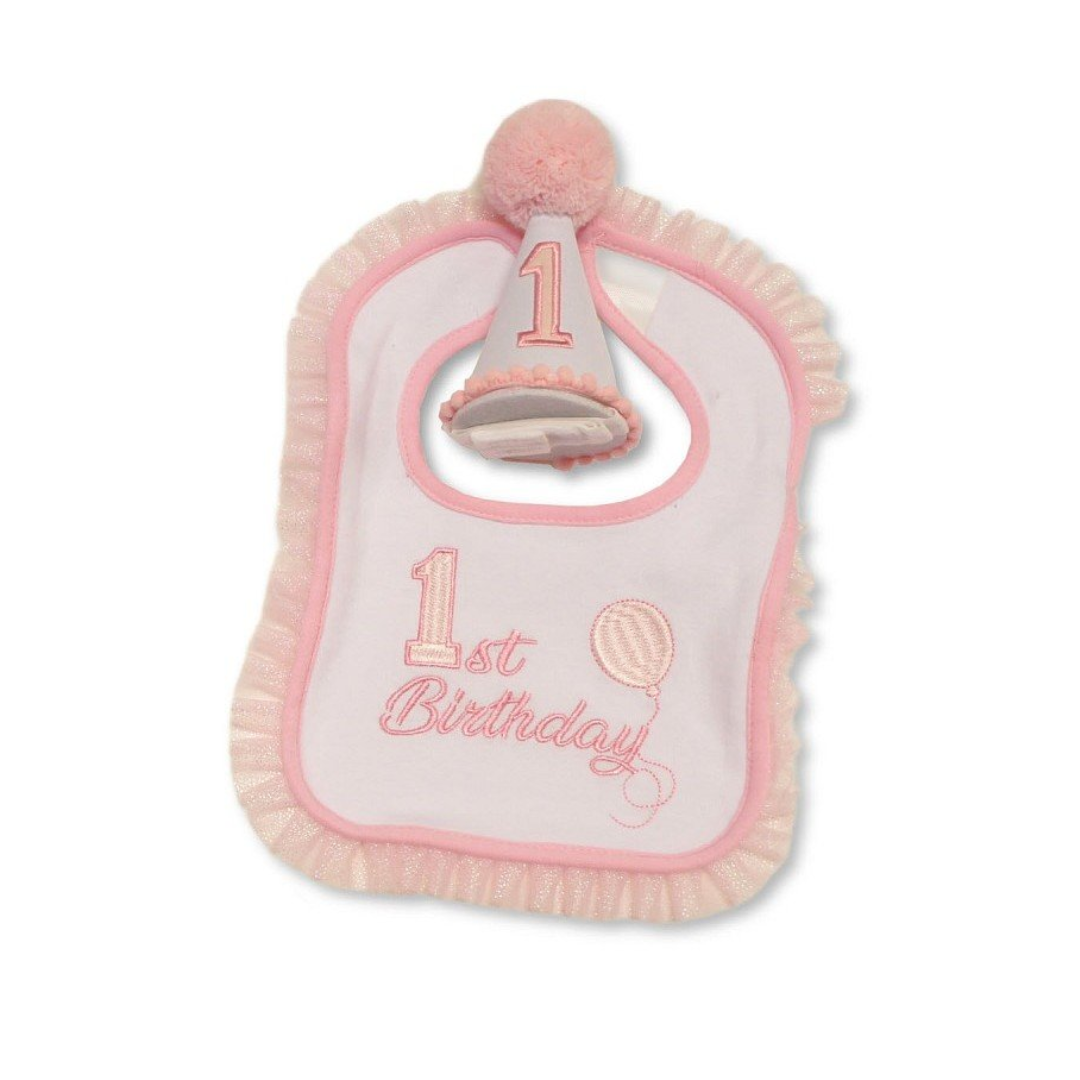 A pink and white plush baby bib with ruffled edges, featuring an embroidered '1st Birthday' design, a small balloon motif, and a party hat with a '1' hanging from the top.