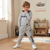 A young boy wearing a light gray two-piece tracksuit with 'Bentley' printed in navy blue on the hoodie and pants, standing in a child's playroom.