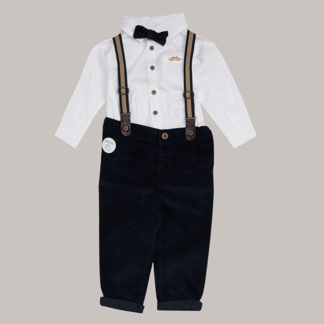 Children's outfit with white shirt, black suspenders, and black pants on a beige background