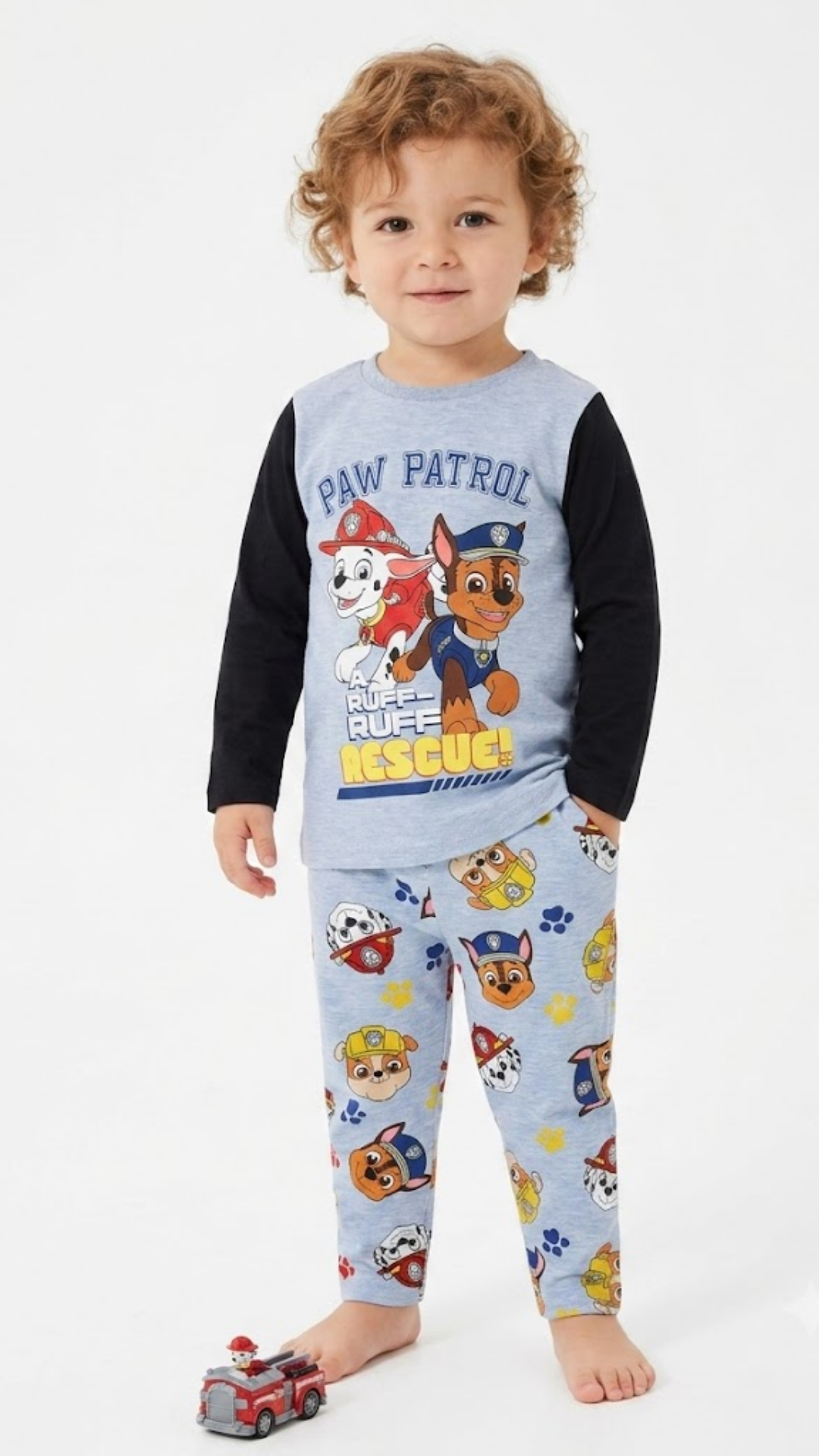 Child wearing Paw Patrol pajamas with a white background