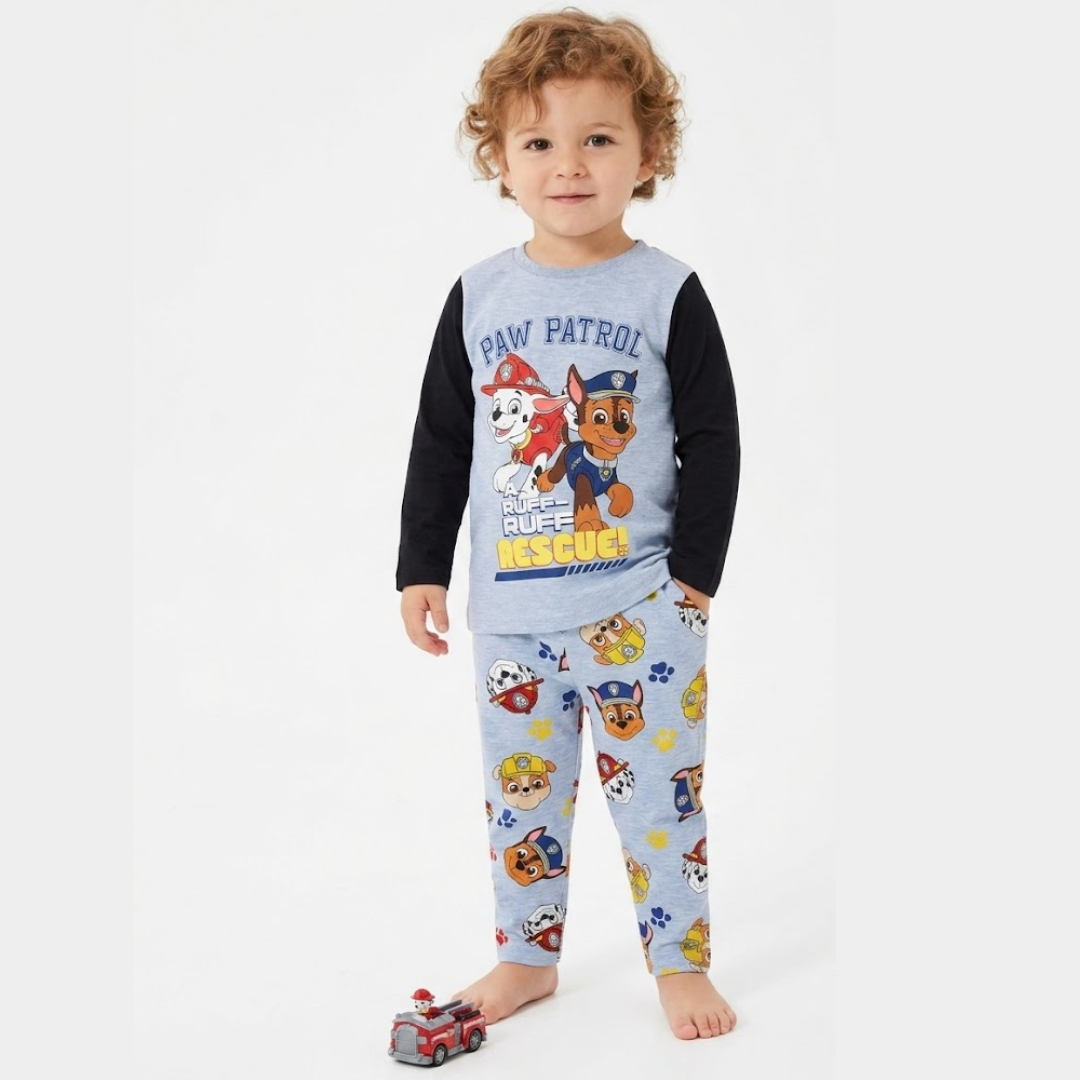 Child wearing Paw Patrol pajamas on a white background