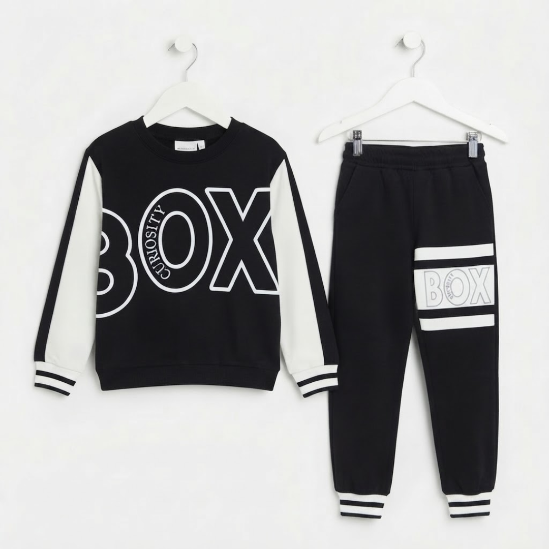 A two-piece kids' outfit set consisting of a black and white long-sleeve sweatshirt and matching black jogger pants, both hanging on white hangers against a plain white background. The sweatshirt features a large white outlined 'BOX' graphic on the front with 'CITYDUTY' written inside the 'O', and white sleeve panels.