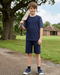 Young boy holding a cricket bat outdoors in a park-like setting