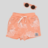 Orange short and sunglasses with grey background
