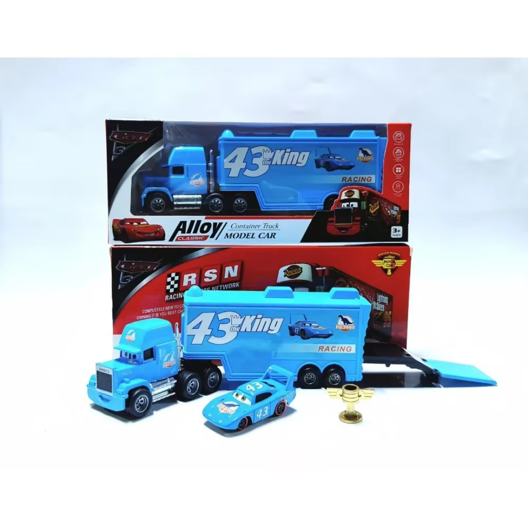 A blue toy semi-truck and race car set displayed in front of its retail packaging. The set includes a blue semi-truck cab, a matching trailer with the number 43, a small blue cartoon-style race car, and a small gold-colored accessory, all shown against a plain white background with the product box behind them.