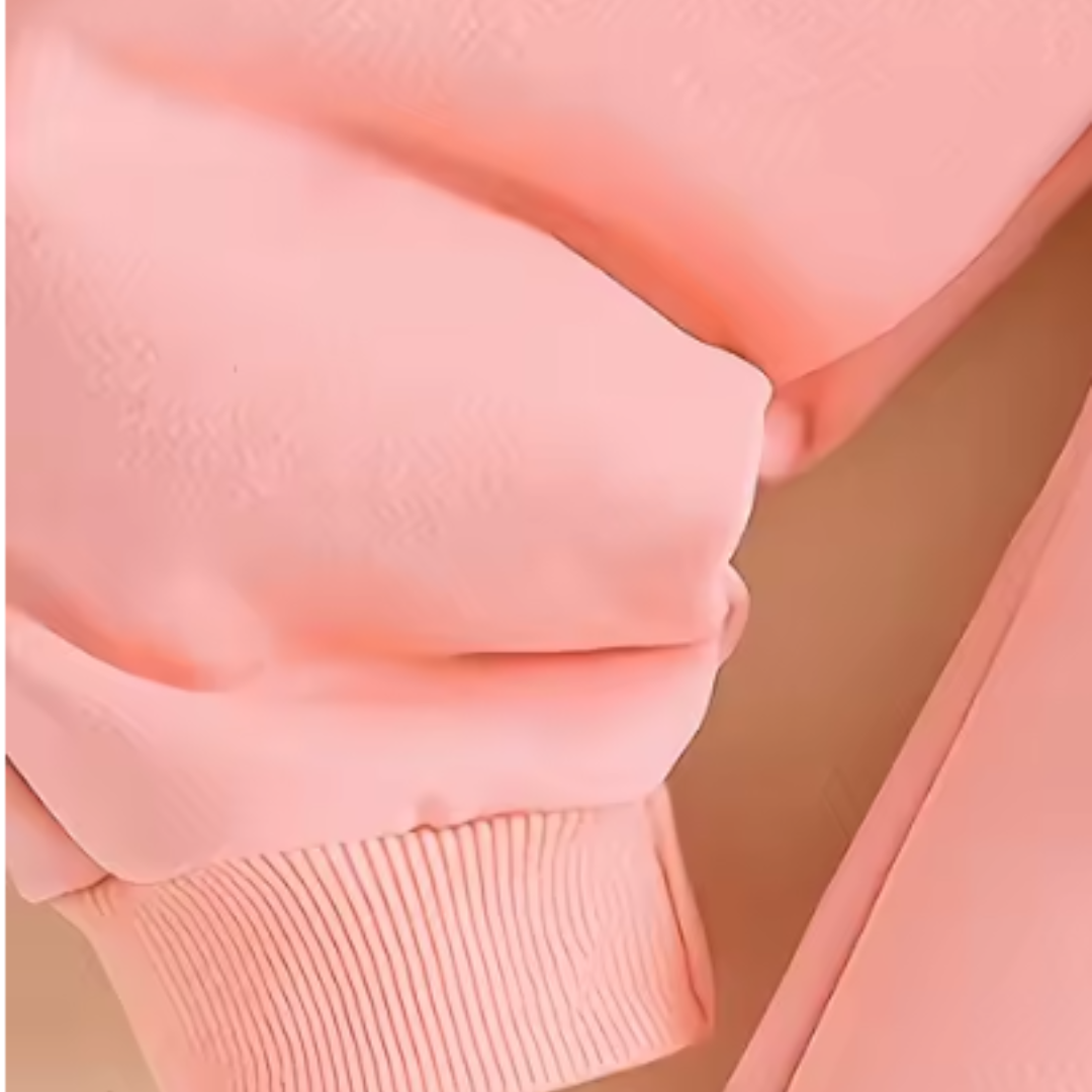 Close-up detail of a light pink garment, showing soft fabric folds and a ribbed cuff.