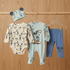 Baby clothing set with Mickey Mouse design on a wooden background