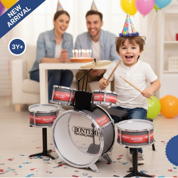 Child playing a toy drum set with family in the background, celebrating a birthday.
