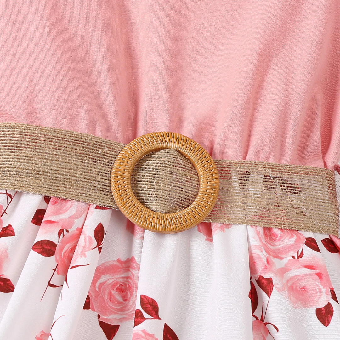 Floral dress with a beige belt and woven buckle on a pink background