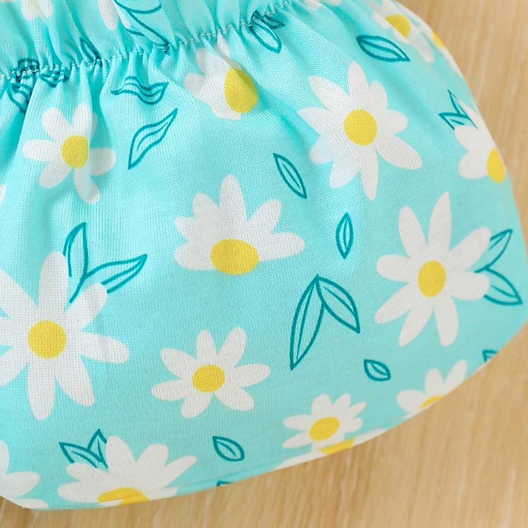 Close-up of a blue fabric with white daisy patterns on a wooden surface