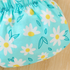 Close-up of a blue fabric with white daisy patterns on a wooden surface