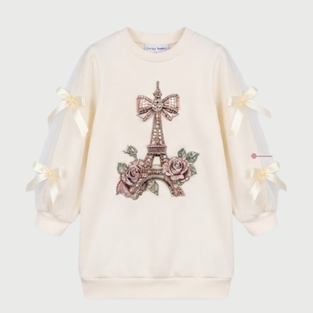 An off-white long-sleeve sweatshirt featuring a central Parisian-themed graphic of the Eiffel Tower adorned with a large bow and pink roses. The sleeves have sheer mesh sections with cream-colored ribbon bows at the cuffs.