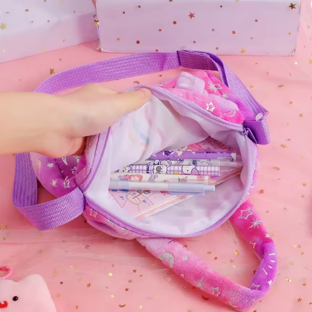 A pink and purple plush pencil case with a hand opening the zipper to show stationery inside, set against a pink background with gold star confetti.