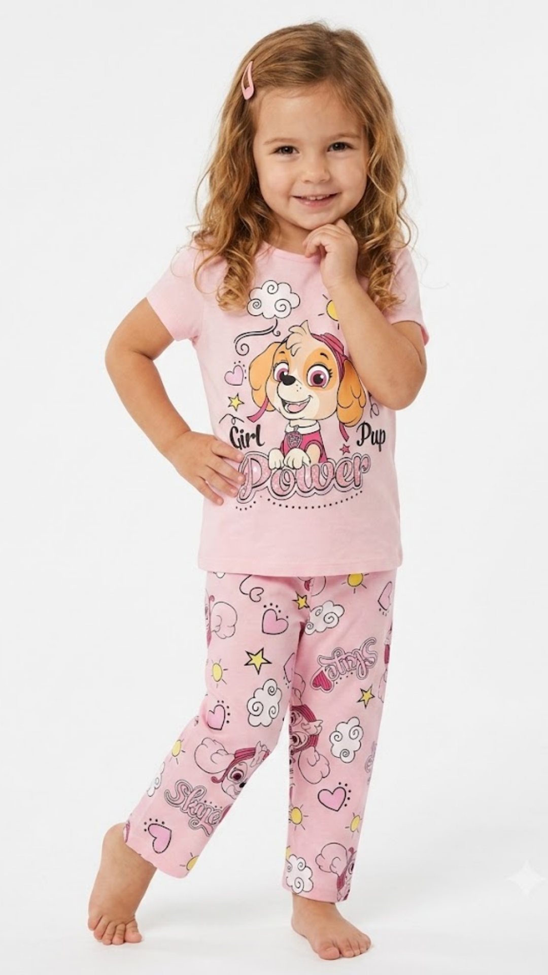 Child wearing pink pajamas with a cartoon character on a white background