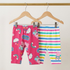 Two pairs of children's leggings on hangers against a white background