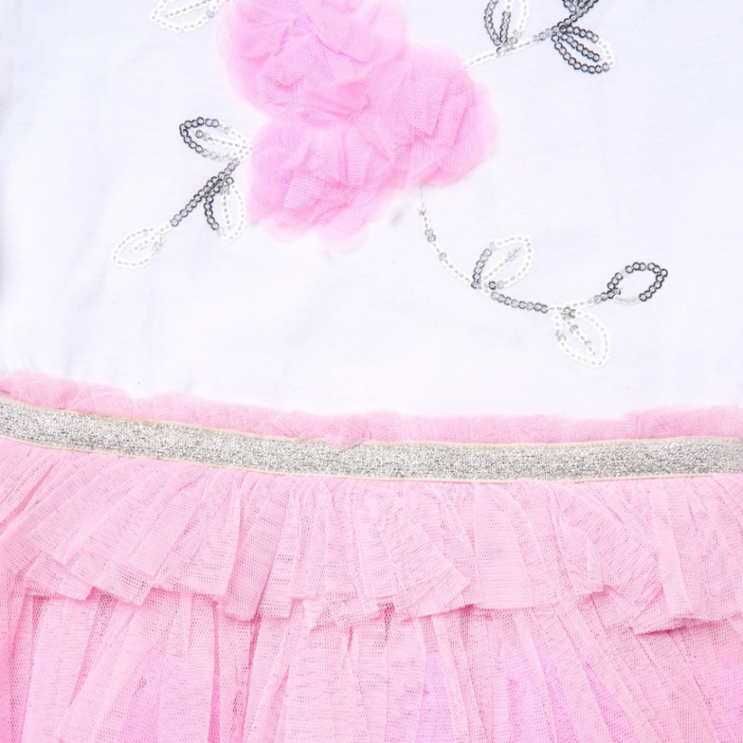 Close-up of a pink dress with floral details and a white background